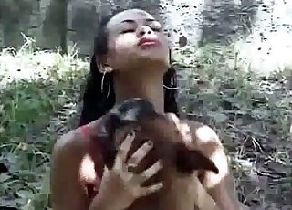 Ebony seduces dog for sex in the forest during XXX bestiality video