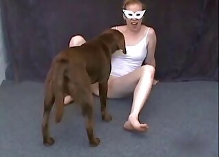 Mask-wearing blonde zoophile enjoying hot cunnilingus with a dog